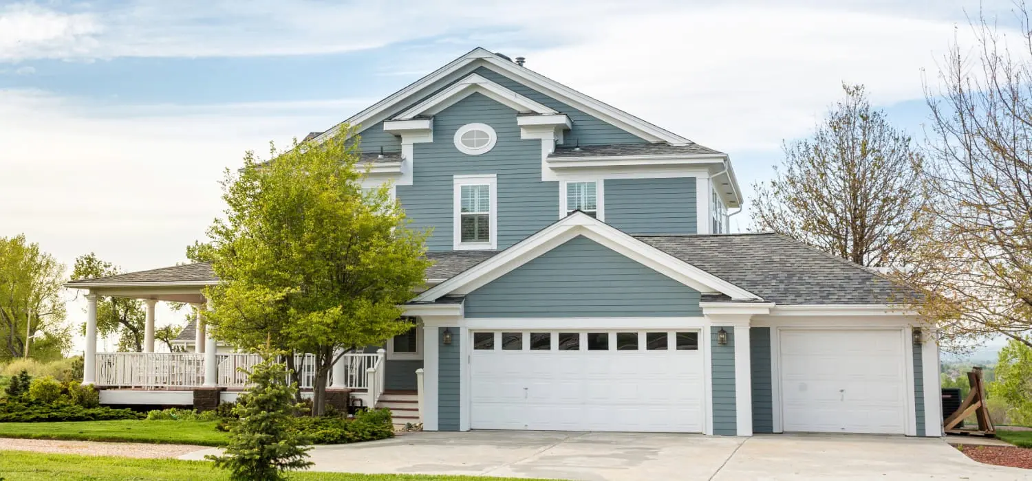 Blue-gray two-story home with crisp white trim, the kind of exterior painters in Lawrence, KS refresh