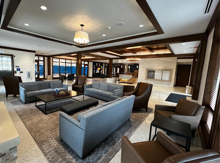 Commercial lobby with white walls, dark wood trim, and a coffered ceiling