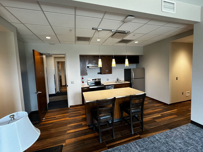 Freshly painted apartment unit with neutral walls, an open kitchen, and wood-look floors
